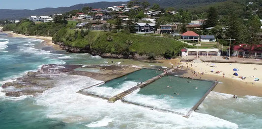 Austinmer's lap pool and children's pool on the rock shelf at Austinmer Beach, with the green Illawarra escarpment behind