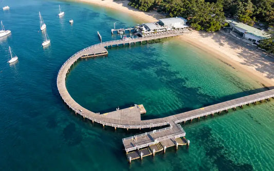 U-shaped timber boardwalk of Balmoral Baths enclosing calm harbour water off Balmoral Beach, Mosman